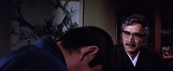 Movie still from “The Yakuza” (1974), directed by Sydney Pollack – A person with their head down in a room; Close Up shot, Over the shoulder angle