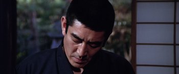 Movie still from “The Yakuza” (1974), directed by Sydney Pollack – A person wearing a black shirt; Close Up shot, Low angle