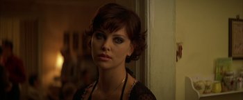 Movie still from “The Yards” (2000), directed by James Gray – A beautiful woman with short brown hair wearing a black top; Close Up shot, Over the shoulder angle