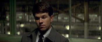 Movie still from “The Yards” (2000), directed by James Gray – A man wearing a suit and tie in front of a window; Close Up shot, Over the shoulder angle