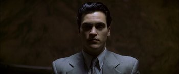 Movie still from “The Yards” (2000), directed by James Gray – A man wearing a suit and tie in front of a dark background; Close Up shot, Low angle