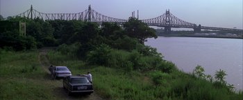 Movie still from “The Yards” (2000), directed by James Gray – A car parked on the side of a river near a bridge; Extreme Wide shot, High angle