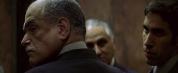 Movie still from “The Yards” (2000), directed by James Gray – A man in a suit and tie next to another man in a suit and tie; Close Up shot, Over the shoulder angle