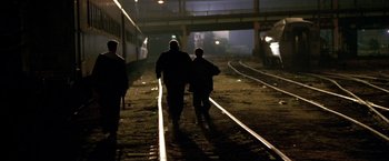 Movie still from “The Yards” (2000), directed by James Gray – Two people walking on train tracks at night; Wide shot, Low angle
