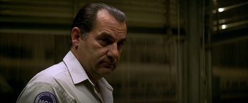 Movie still from “The Yards” (2000), directed by James Gray – A man with a beard and mustache wearing a white dress shirt; Close Up shot, Low angle