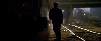 Movie still from “The Yards” (2000), directed by James Gray – A man standing on the side of a road at night; Wide shot, Low angle