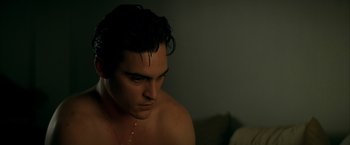 Movie still from “The Yards” (2000), directed by James Gray – A shirtless man with wet hair sitting on a couch; Close Up shot, High angle