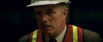 Movie still from “The Yards” (2000), directed by James Gray – An older man wearing a white hard hat and vest; Close Up shot, Low angle