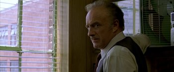 Movie still from “The Yards” (2000), directed by James Gray – An older man wearing a neck tie looking out of a window; Close Up shot, Low angle