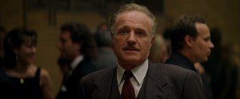 Movie still from “The Yards” (2000), directed by James Gray – An older man in a suit and tie looking at the camera; Close Up shot, Low angle