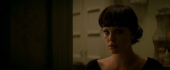 Movie still from “The Yards” (2000), directed by James Gray – A beautiful woman with bangs looking at the camera; Close Up shot, Over the shoulder angle