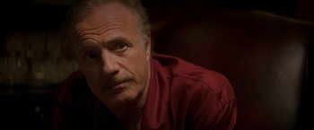 Movie still from “The Yards” (2000), directed by James Gray – An older man in a red shirt looks at the camera; Close Up shot, Low angle