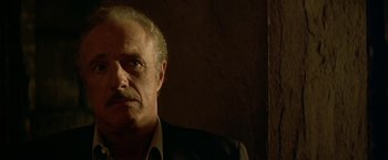 Movie still from “The Yards” (2000), directed by James Gray – An older man in a suit looking at the camera; Close Up shot, Low angle