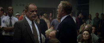 Movie still from “The Yards” (2000), directed by James Gray – Two men in suits talking to each other in front of a group of people; Medium shot, Low angle