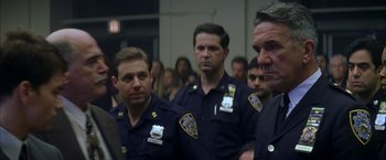 Movie still from “The Yards” (2000), directed by James Gray – A group of police officers standing next to each other in a room; Close Up shot, Over the shoulder angle