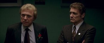 Movie still from “The Yards” (2000), directed by James Gray – Two men in suits sitting next to each other in a room; Close Up shot, Over the shoulder angle