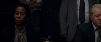 Movie still from “The Yards” (2000), directed by James Gray – A man in a suit standing next to another man in a gray suit; Close Up shot, Over the shoulder angle