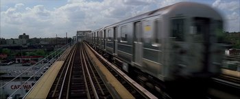 Movie still from “The Yards” (2000), directed by James Gray – A train traveling down the tracks near a train station; Extreme Wide shot, Low angle