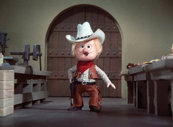 Movie still from “The Year Without a Santa Claus” (1974), directed by Jules Bass – A toy cowboy is standing in front of an arched doorway; Medium shot, Low angle