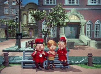 Movie still from “The Year Without a Santa Claus” (1974), directed by Jules Bass – A group of cartoon characters sitting on a bench; Wide shot, High angle