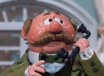 Movie still from “The Year Without a Santa Claus” (1974), directed by Jules Bass – The head of a doll with a fake mustache; Close Up shot, Low angle