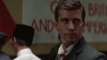 Movie still from “The Year of Living Dangerously” (1982), directed by Peter Weir – A man wearing a suit and tie standing next to another man wearing a suit; Close Up shot, Low angle