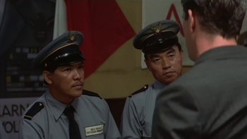 Movie still from “The Year of Living Dangerously” (1982), directed by Peter Weir – Two men in uniform are looking at each other; Medium shot, Over the shoulder angle