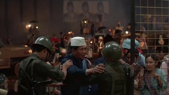 Movie still from “The Year of Living Dangerously” (1982), directed by Peter Weir – A group of men in military uniforms are greeting each other; Wide shot, High angle