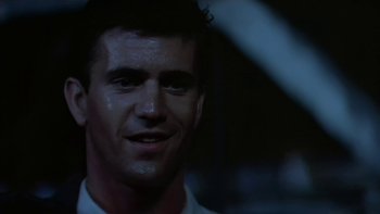 Movie still from “The Year of Living Dangerously” (1982), directed by Peter Weir – A person wearing a white t - shirt; Close Up shot, Low angle