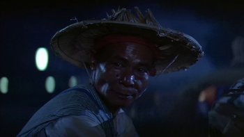 Movie still from “The Year of Living Dangerously” (1982), directed by Peter Weir – A man wearing a straw hat and a striped shirt; Close Up shot, Low angle