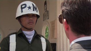Movie still from “The Year of Living Dangerously” (1982), directed by Peter Weir – A man wearing a helmet talking to another man in front of a wall; Close Up shot, Low angle