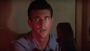Movie still from “The Year of Living Dangerously” (1982), directed by Peter Weir – A person with a microphone; Close Up shot, Low angle