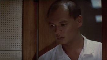 Movie still from “The Year of Living Dangerously” (1982), directed by Peter Weir – A person wearing a white shirt; Close Up shot, Low angle