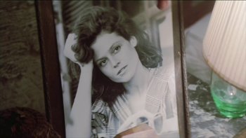 Movie still from “The Year of Living Dangerously” (1982), directed by Peter Weir – An old photo of a woman with long hair; Extreme Close Up shot, High angle