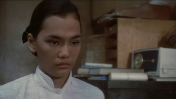 Movie still from “The Year of Living Dangerously” (1982), directed by Peter Weir – A man in a white shirt is looking at the camera; Close Up shot, High angle