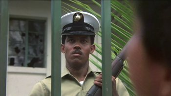 Movie still from “The Year of Living Dangerously” (1982), directed by Peter Weir – A man in a uniform holding a rifle; Close Up shot, Low angle