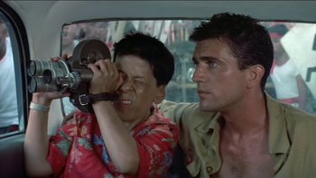 Movie still from “The Year of Living Dangerously” (1982), directed by Peter Weir – A man and a boy in the back of a car; Close Up shot, Low angle