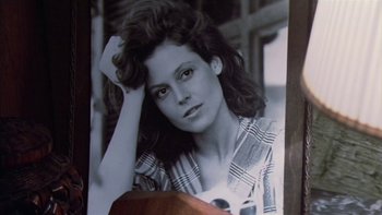 Movie still from “The Year of Living Dangerously” (1982), directed by Peter Weir – A black and white photo of a woman in a plaid shirt; Close Up shot, Low angle