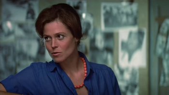 Movie still from “The Year of Living Dangerously” (1982), directed by Peter Weir – A person wearing a blue shirt; Close Up shot, Over the shoulder angle