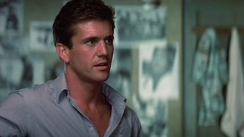 Movie still from “The Year of Living Dangerously” (1982), directed by Peter Weir – A person wearing a shirt; Close Up shot, Over the shoulder angle