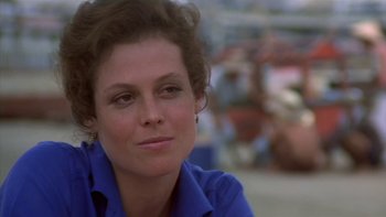 Movie still from “The Year of Living Dangerously” (1982), directed by Peter Weir – A person wearing a blue shirt; Close Up shot, Over the shoulder angle
