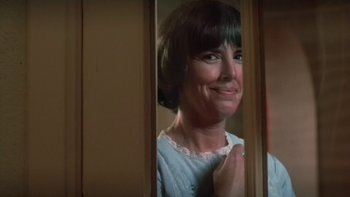 Movie still from “The Year of Living Dangerously” (1982), directed by Peter Weir – A person standing in a room; Close Up shot, Low angle