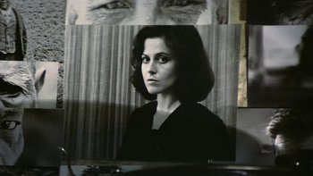Movie still from “The Year of Living Dangerously” (1982), directed by Peter Weir – A black - and - white photo of a woman and a picture of an old man's face; Extreme Close Up shot, High angle