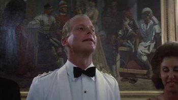 Movie still from “The Year of Living Dangerously” (1982), directed by Peter Weir – A man wearing a white shirt and a bow tie; Close Up shot, Low angle