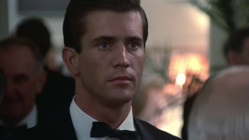 Movie still from “The Year of Living Dangerously” (1982), directed by Peter Weir – A person wearing a suit and a bow tie; Close Up shot, Low angle