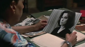 Movie still from “The Year of Living Dangerously” (1982), directed by Peter Weir – A person looking at a picture of a woman; Close Up shot, High angle