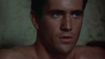 Movie still from “The Year of Living Dangerously” (1982), directed by Peter Weir – A man with blue eyes looking at the camera; Close Up shot, Low angle