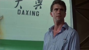 Movie still from “The Year of Living Dangerously” (1982), directed by Peter Weir – A person standing in front of a wall; Close Up shot, Low angle