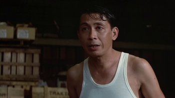 Movie still from “The Year of Living Dangerously” (1982), directed by Peter Weir – A person wearing a tank top; Close Up shot, Low angle