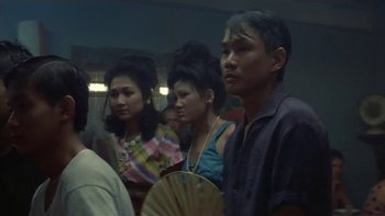 Movie still from “The Year of Living Dangerously” (1982), directed by Peter Weir – A group of people standing in front of a mirror; Medium shot, High angle